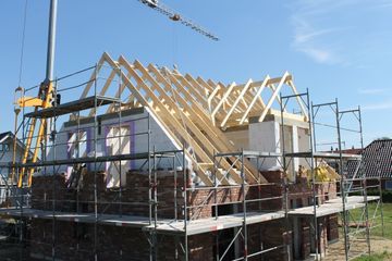 Ein im Bau befindliches Haus mit einem Kran im Hintergrund