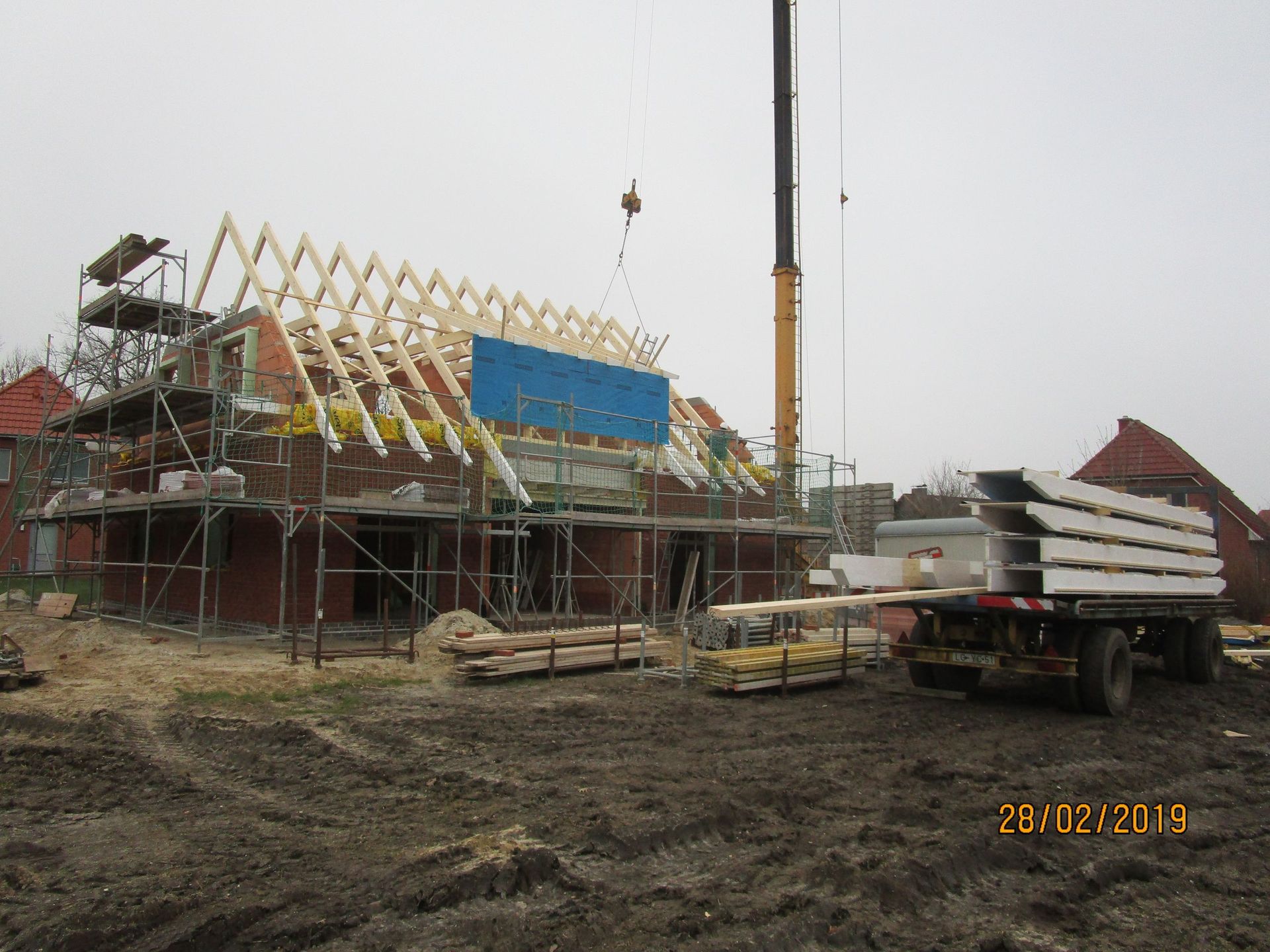 Ein LKW parkt vor einem im Bau befindlichen Gebäude.