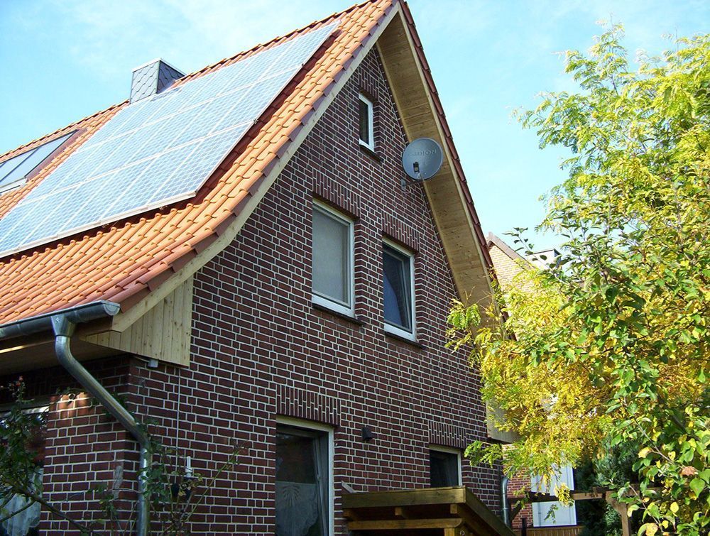 Ein Backsteinhaus mit Solarzellen auf dem Dach