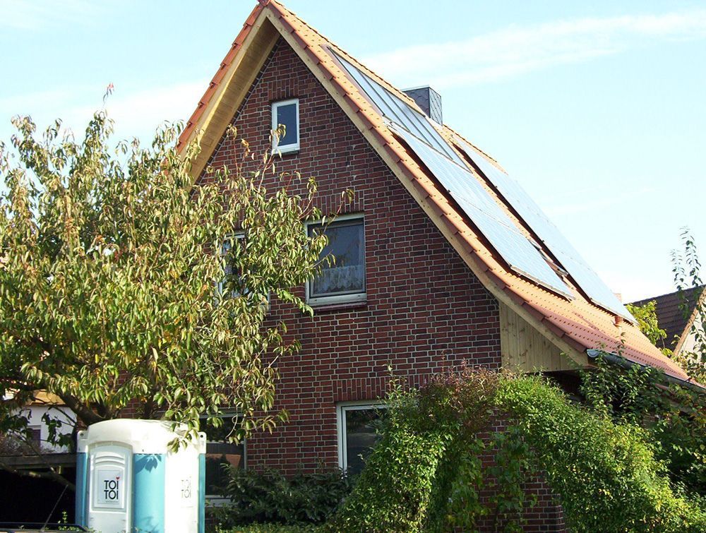 Ein Backsteinhaus mit Solarzellen auf dem Dach