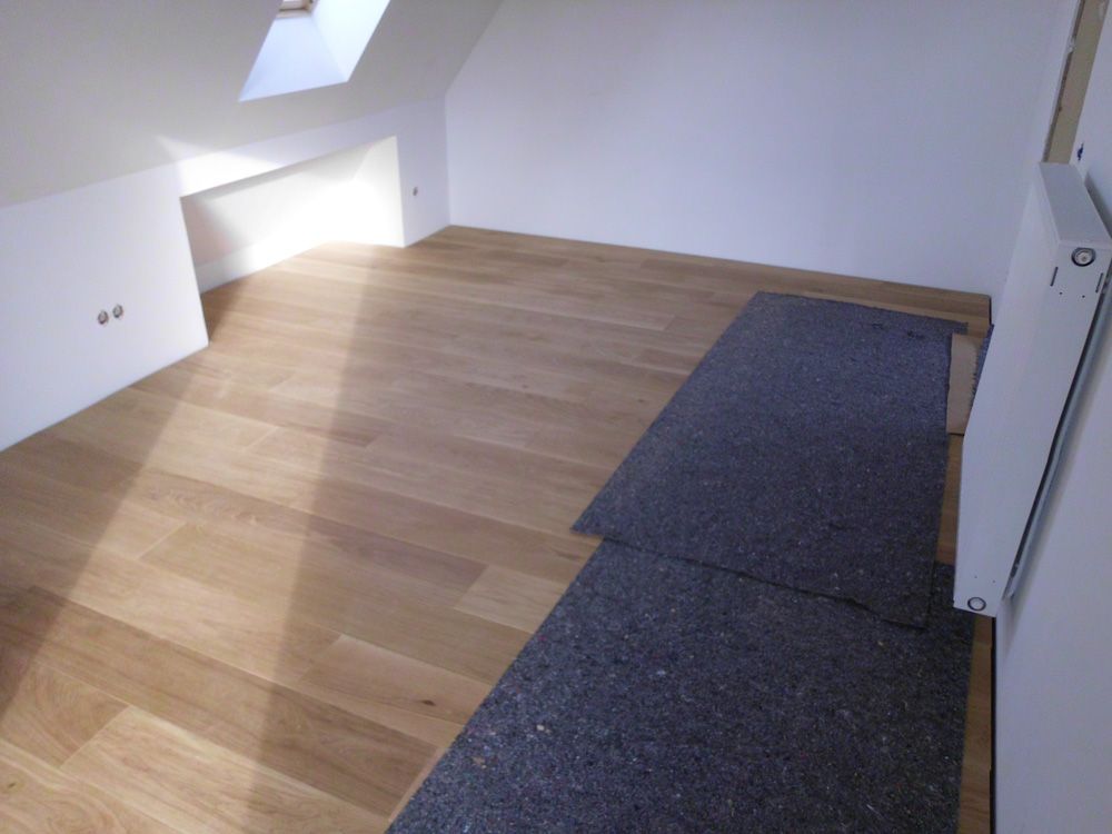 Ein Raum mit Holzboden und weißen Wänden