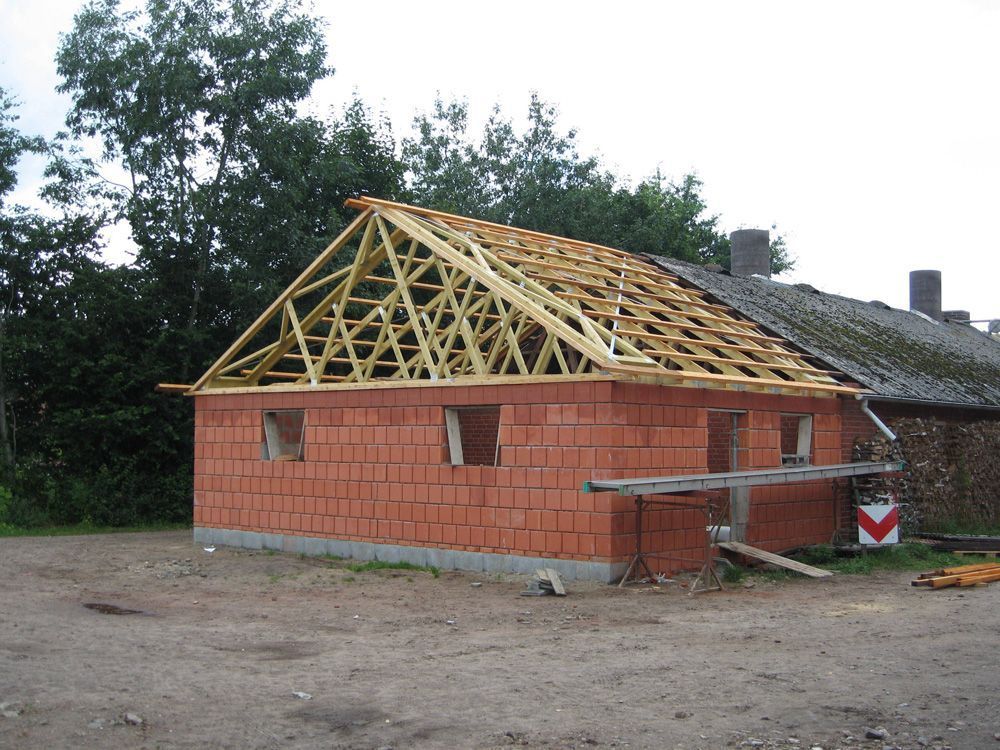 Ein im Bau befindliches Backsteingebäude mit einem Holzdach