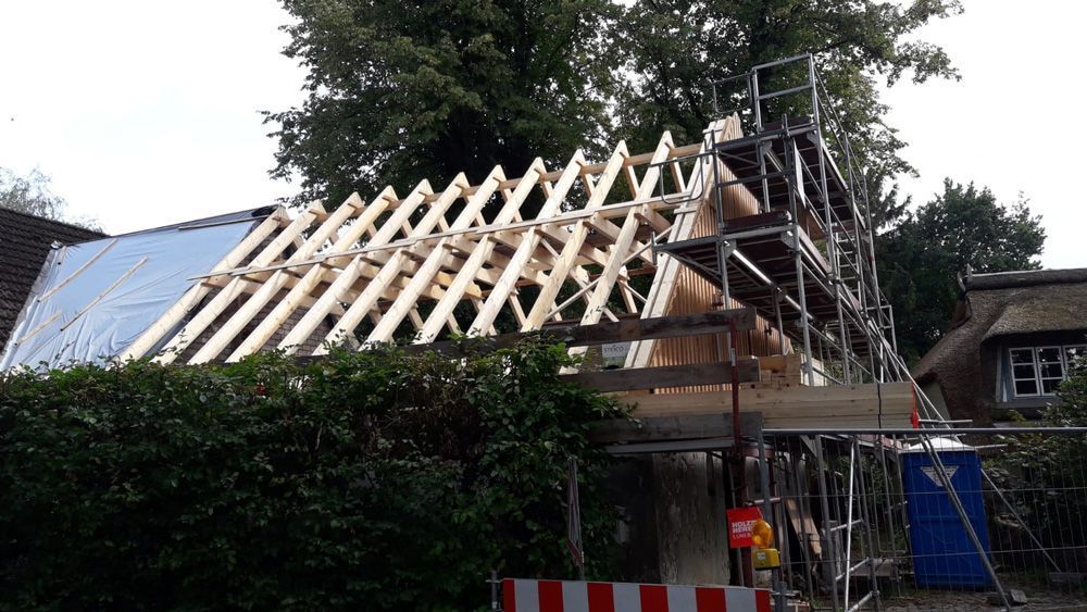 Auf einem Haus wird ein Holzdach errichtet.