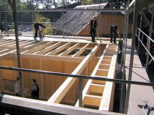 Eine Gruppe von Menschen arbeitet an einer Holzkonstruktion