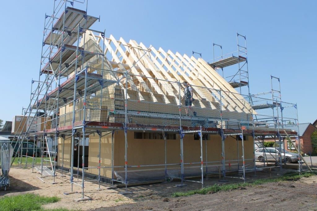 Es wird ein Haus gebaut, das von einem Gerüst umgeben ist.