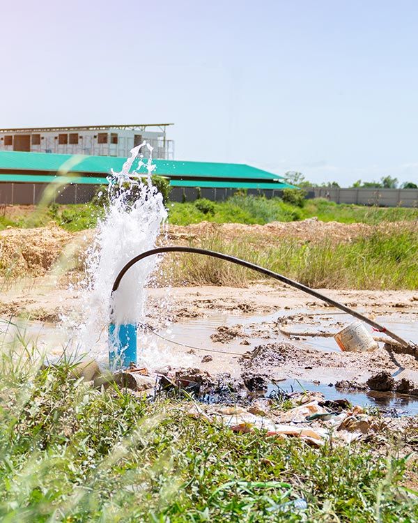 Eau sortant du sol dans un champ d'herbe et de terre