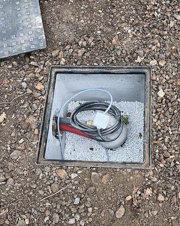 Pompe à eau immergée installée dans un sol de cailloux