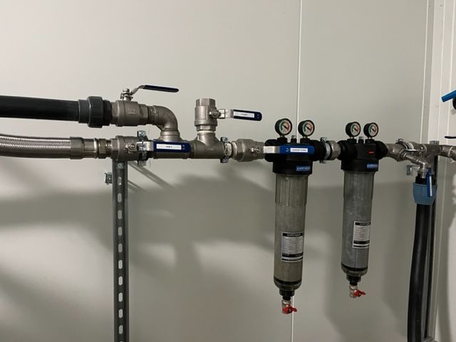 Technicien resserrant un écrou d'un adoucisseur d'eau à l'aide d'une clef