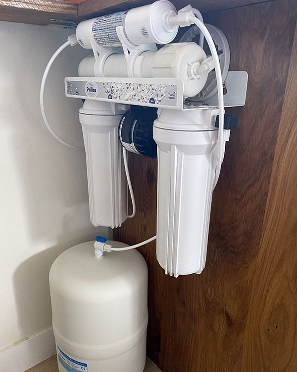 Système de réservoir et adoucisseurs d'eau blanc fixé au mur à l'intérieur d'une maison