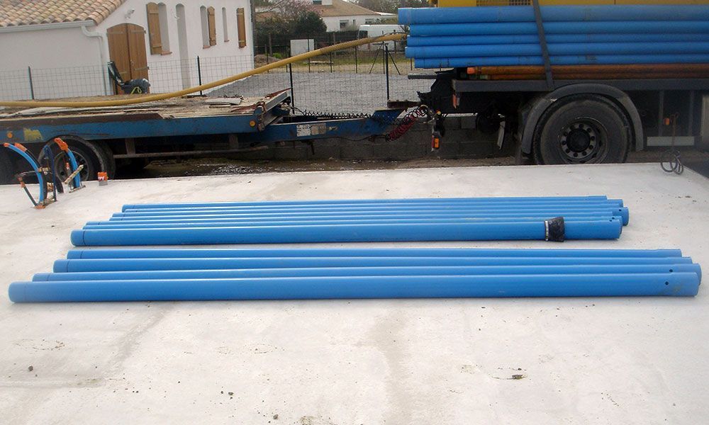 Plusieurs tuyaux bleu posés sur le sol