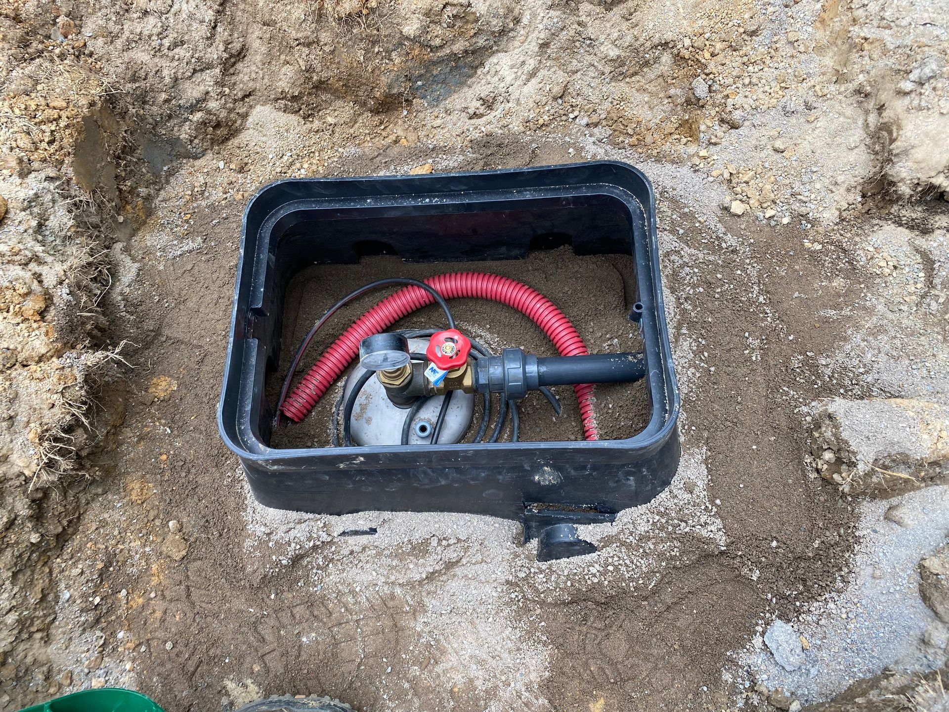 Dalle de béton dans le sol où sort un système de tuyau et valves