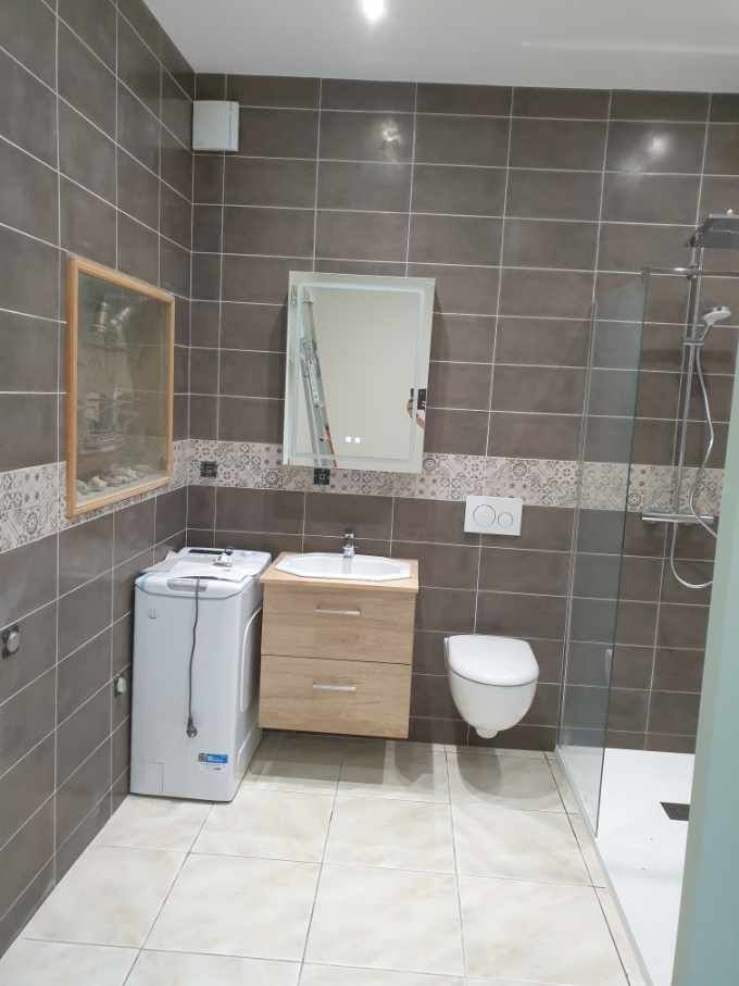 Une salle de bains avec des murs carrelés gris