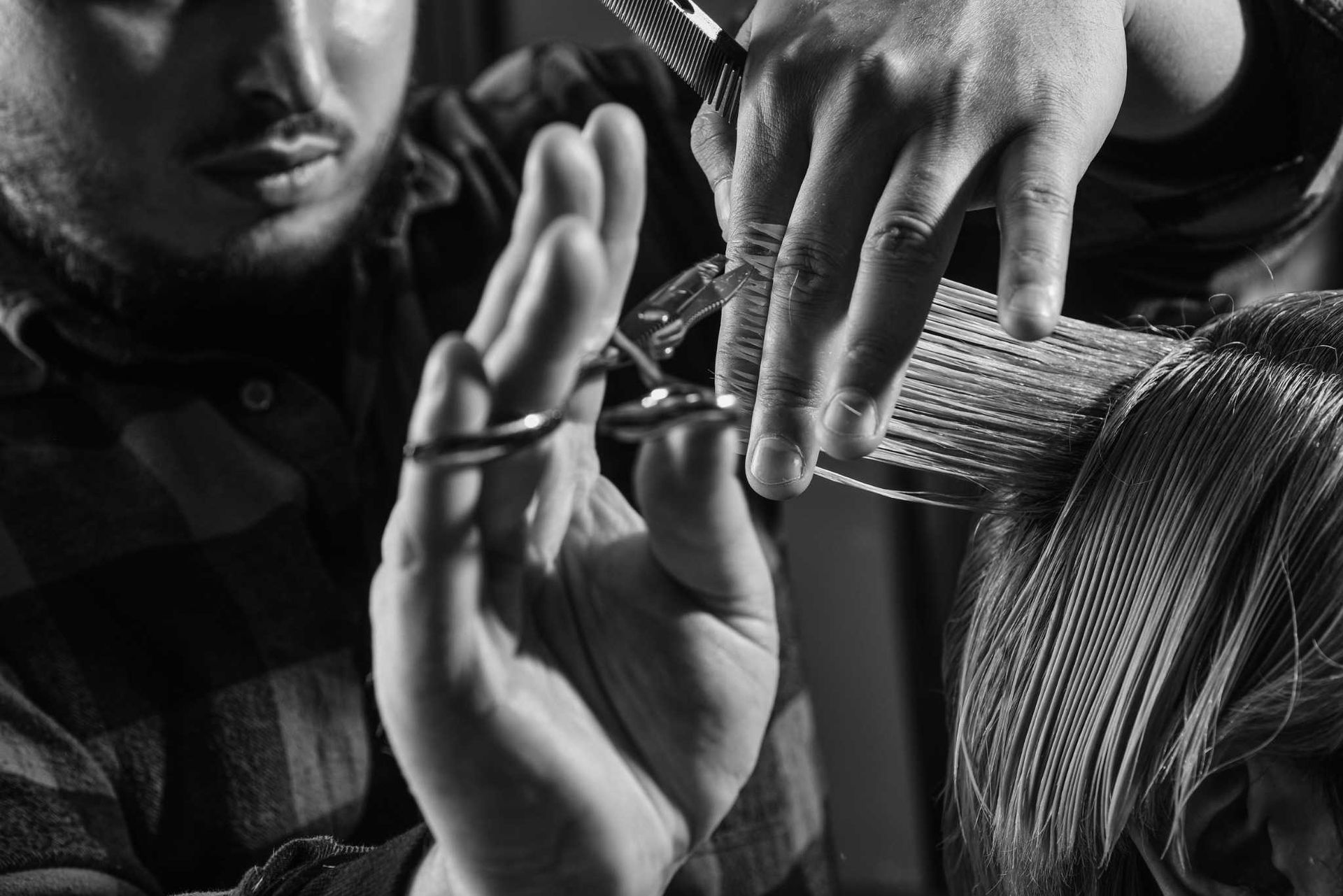 Manos cortando cabello en blanco y negro.