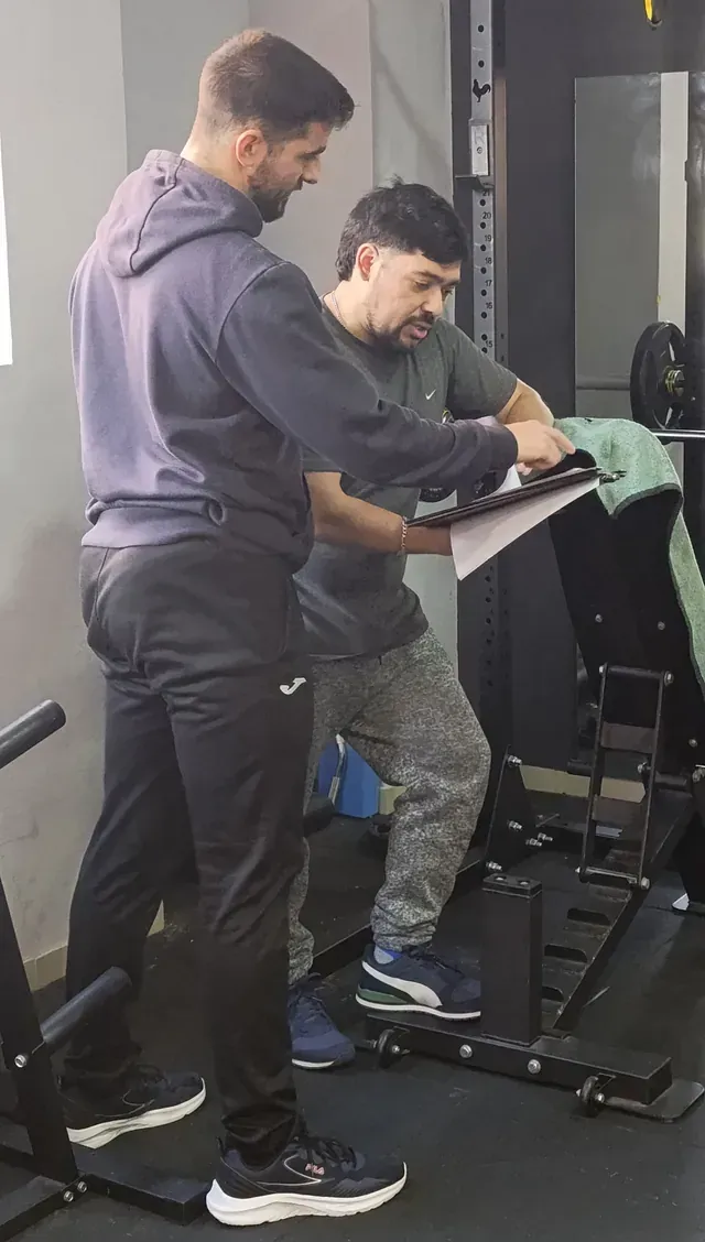 Dos hombres están parados uno al lado del otro en un gimnasio.