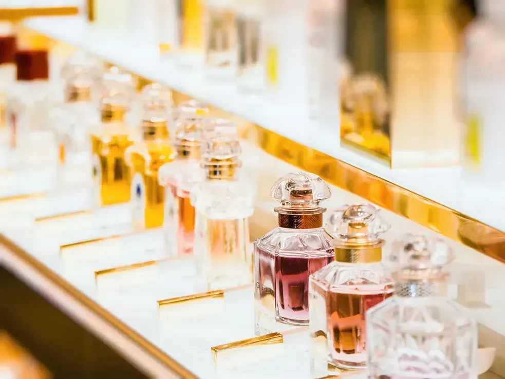 Una fila de frascos de perfume en un estante de una tienda.