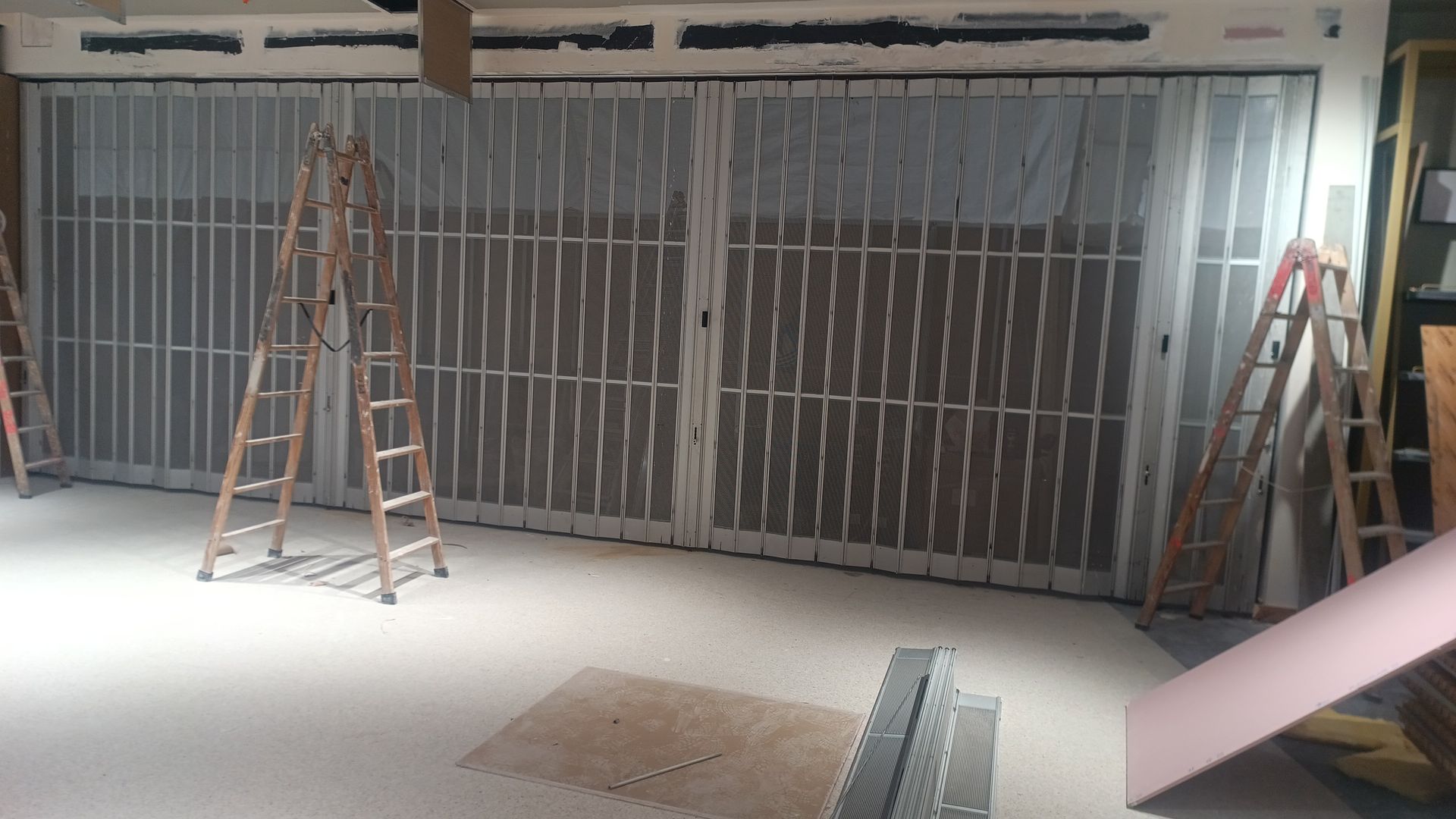 Habitación vacía en obras, con estructura metálica para las paredes y escaleras a ambos lados