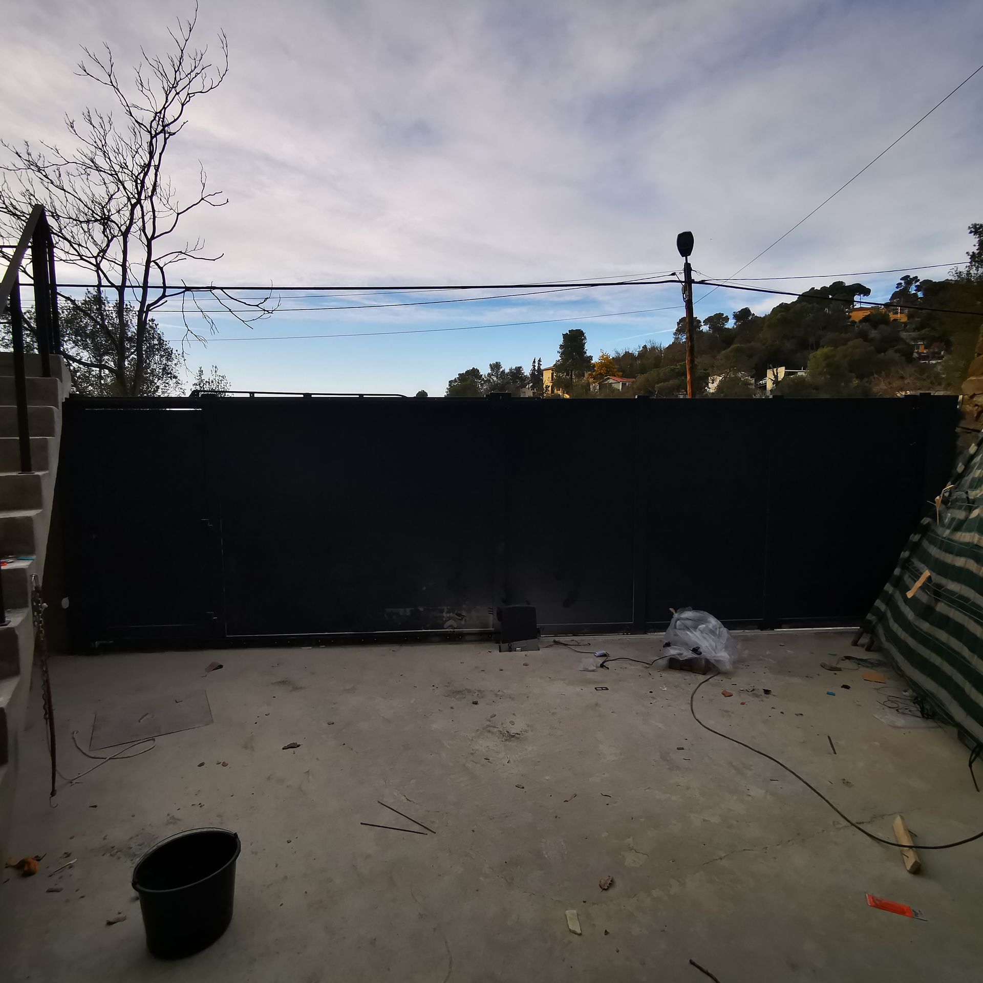 Muelle de carga exterior vacío, con una larga barrera roja y una pared negra de chapa ondulada bajo el letrero