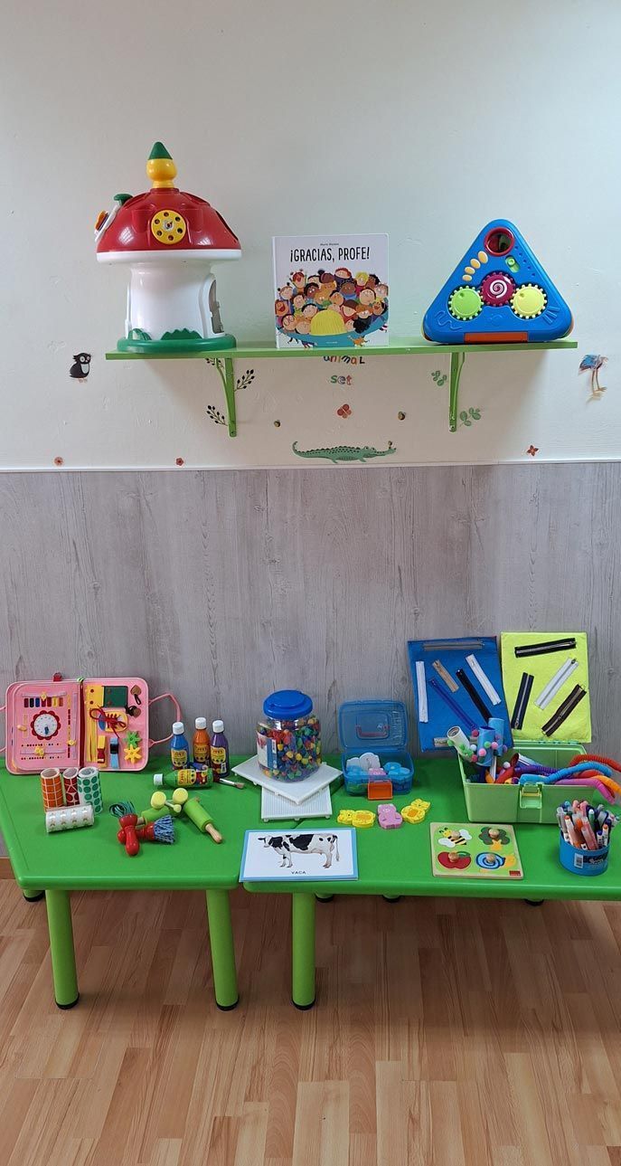 Una mesa verde con muchos juguetes encima en una habitación.