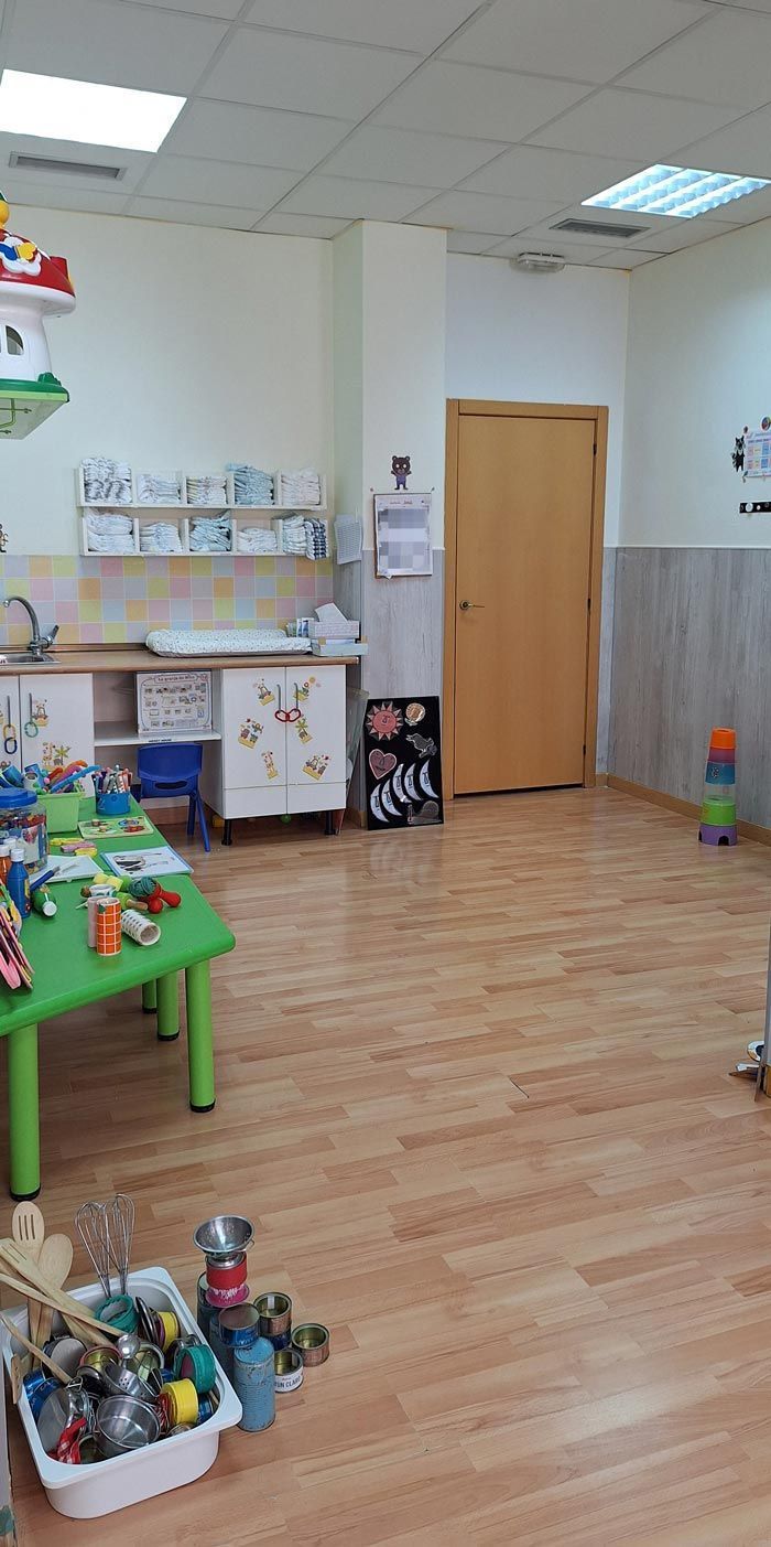 Una habitación llena de muchos juguetes y una mesa verde.