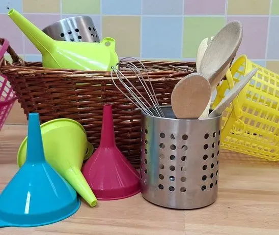 Un montón de utensilios de cocina están en una cesta.