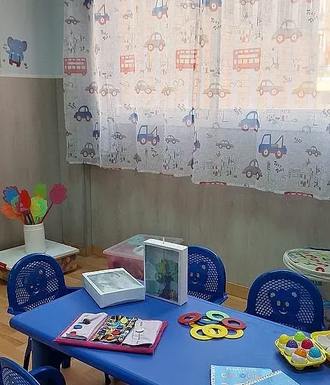 Una habitación infantil con una mesa y sillas azules.