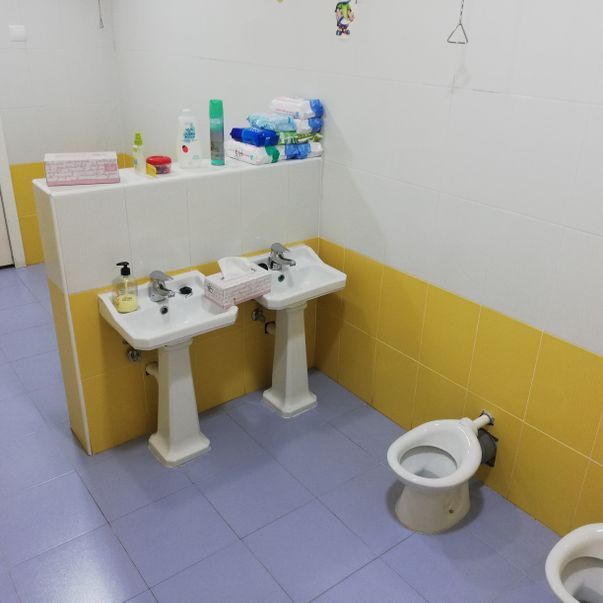 Un baño con dos lavabos y un inodoro.