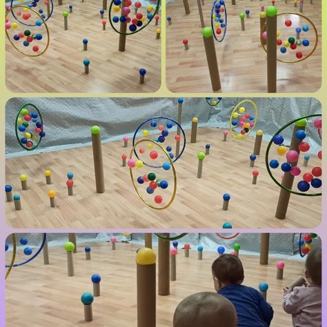 Un niño está jugando con un montón de bolas de colores en un piso de madera.