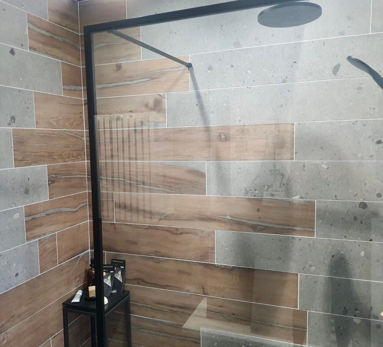 Une douche à l'italienne avec des carreaux muraux avec lames imitation bois et pierre grise texturée