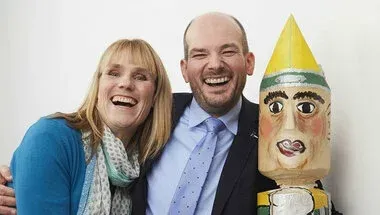 Ein Mann und eine Frau posieren neben einer Puppe für ein Foto.