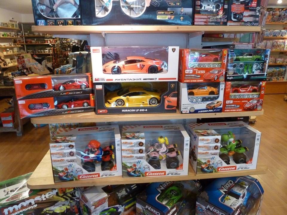 Présentoir de boîtes colorées de voitures et de camions miniatures empilées sur des étagères dans une allée de magasin