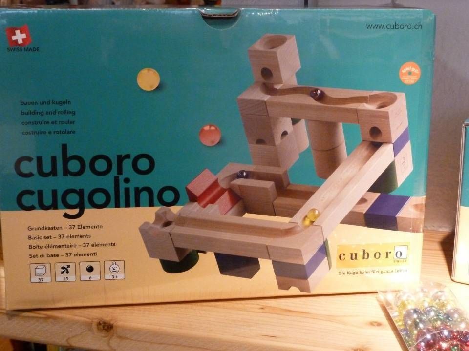Coffret de circuit à billes en bois Cuboro Cugolino avec circuit assemblé sur fond turquoise