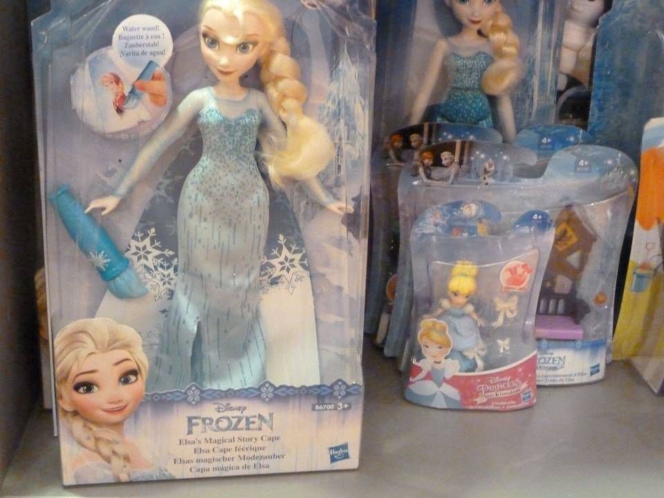 Poupée Elsa de La Reine des Neiges en robe bleue, avec accessoires et tasse dans leur boîte, sur une étagère de magasin