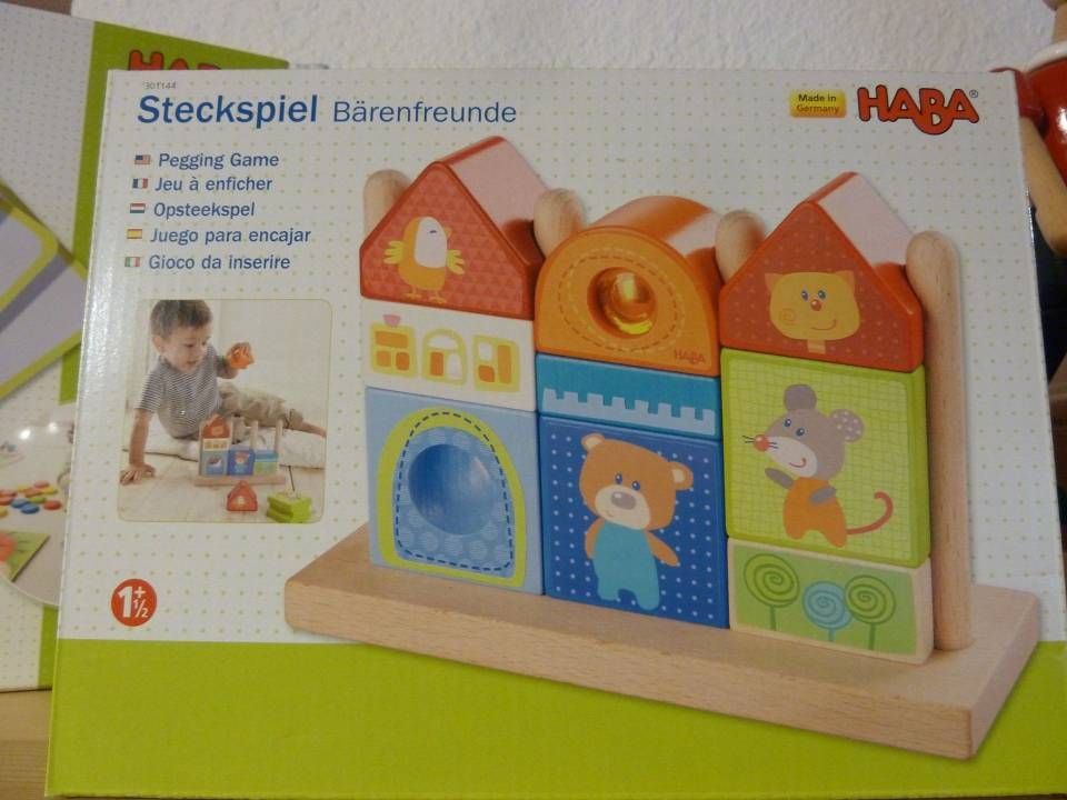 Coffret de jeu d'empilage HABA Steckspeil sur le thème des ours, avec des blocs de bois colorés et une illustration d'enfant qui joue