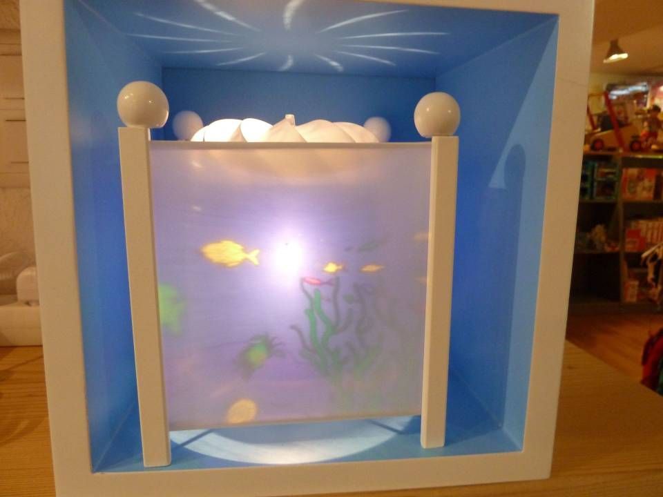 Présentoir lumineux sur le thème des poissons à l'intérieur d'un cadre bleu en forme de boîte avec des montants blancs et un panneau central lumineux