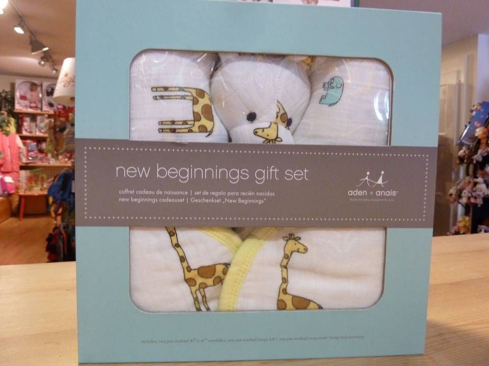 Coffret cadeau bleu contenant des vêtements blancs pour bébé et un motif girafe exposé dans un magasin