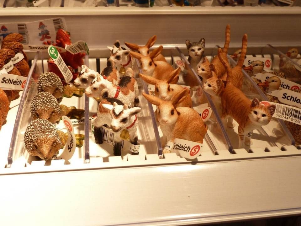 Figurines miniatures d'animaux disposées sur les étagères d'un magasin, représentant notamment des cerfs, des renards et des chats.
