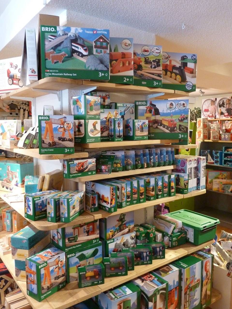 Rayon de présentation de jouets rempli de boîtes et de figurines dans une allée de magasin