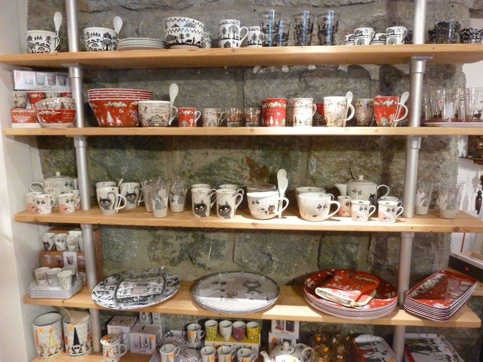 Étagères présentant des théières, des tasses et des assiettes en céramique à motifs assortis dans un magasin