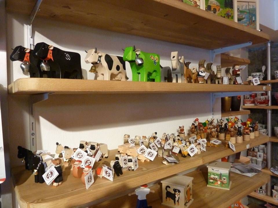 Présentation d'étagères contenant de petits animaux et figurines disposés sur des étagères en bois dans une pièce