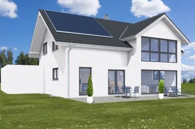 Weißes zweistöckiges Haus mit Solarpaneelen auf dem Dach, großen Fenstern, Terrasse und grünem Rasen unter blauem Himmel.