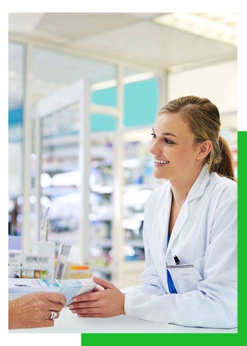 Una farmacéutica está hablando con un paciente en una farmacia.