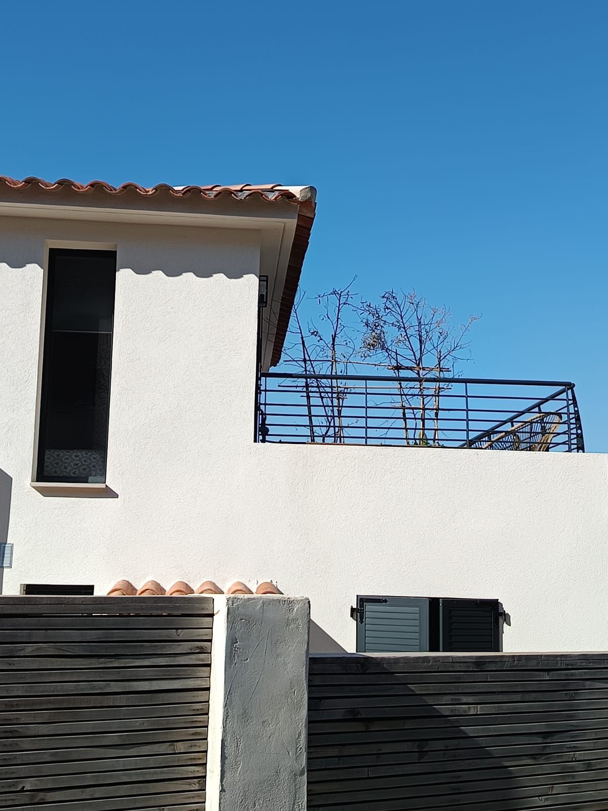 Deux expertes avec des casques blancs sur un chantier montrent un plan à un homme avec un casque jaune