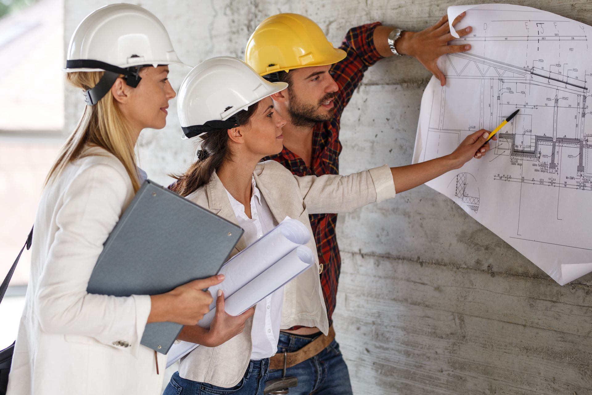 3 ingénieurs analyent un plan sur un chantier