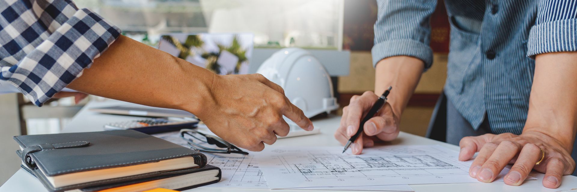 Gros plan sur les mains d'experts analysant le plan d'un bien