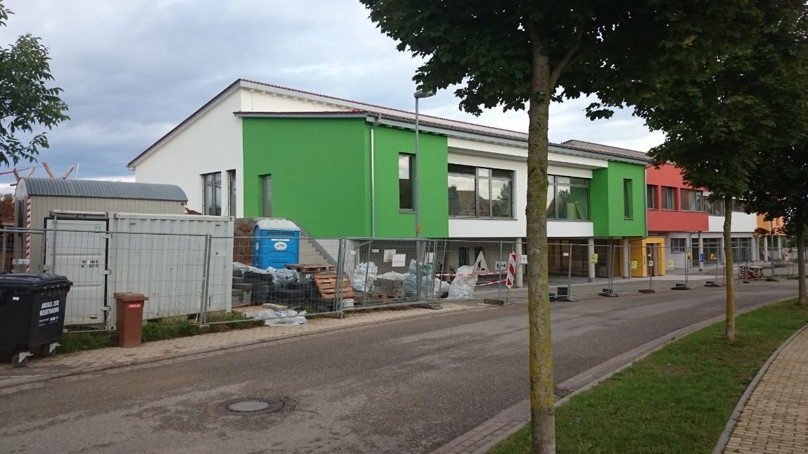 Ein buntes Geschäftsgebäude mit einer Straße und Baumaterialien davor.