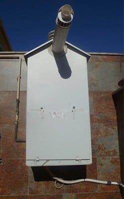 Una caja blanca con una chimenea en el costado de un edificio.