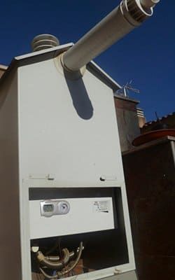 Un edificio blanco del que sale una tubería.