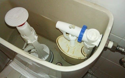 Un primer plano de un tanque de inodoro con un grifo en él.