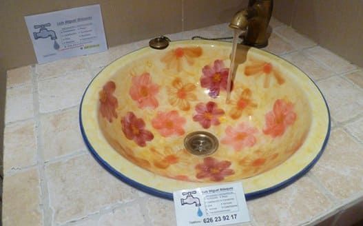 Un lavabo de baño con flores y un grifo.