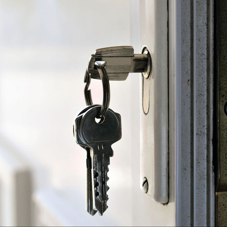 Une clé métallique insérée dans une serrure de porte.
